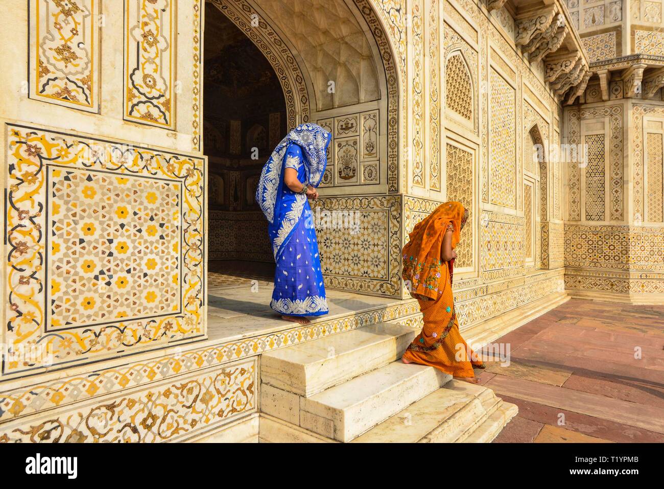 AGRA; INDIA, 12-10-2013: Indian women in colorful saris leaving the mausoleum Itimad ud Daula in Agra, famous for its decoration Stock Photo