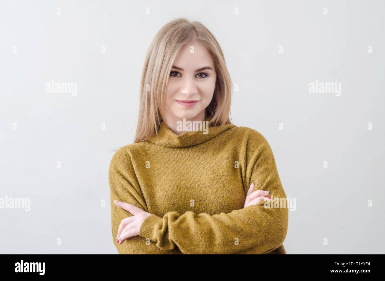 Girl in a green sweater posing on white background Stock Photo - Alamy