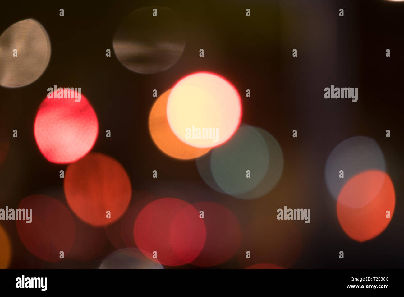 Abstract multicolored bokeh balls floating across a dark background Stock Photo