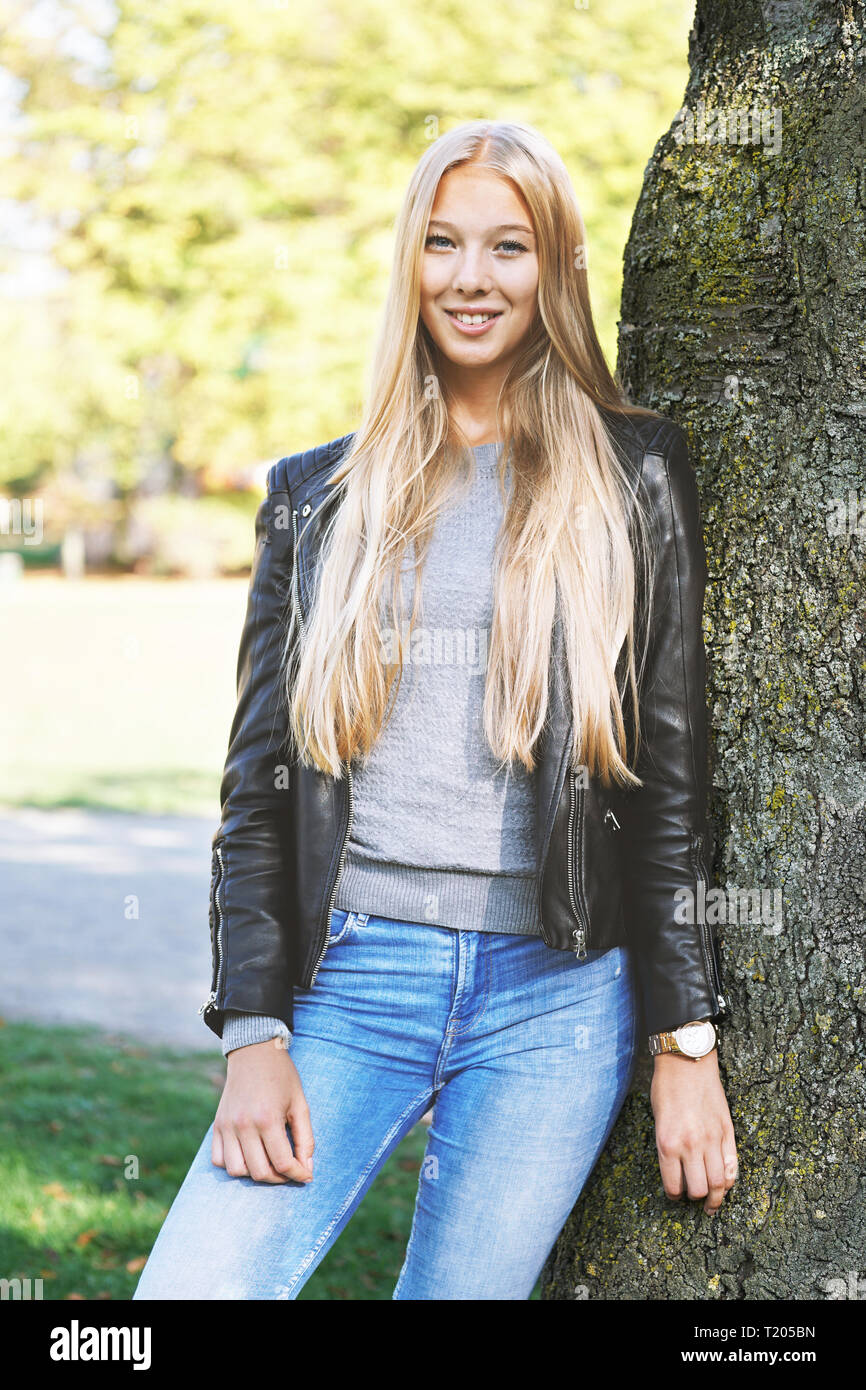 Young girl leaning against tree hi-res stock photography and images - Alamy
