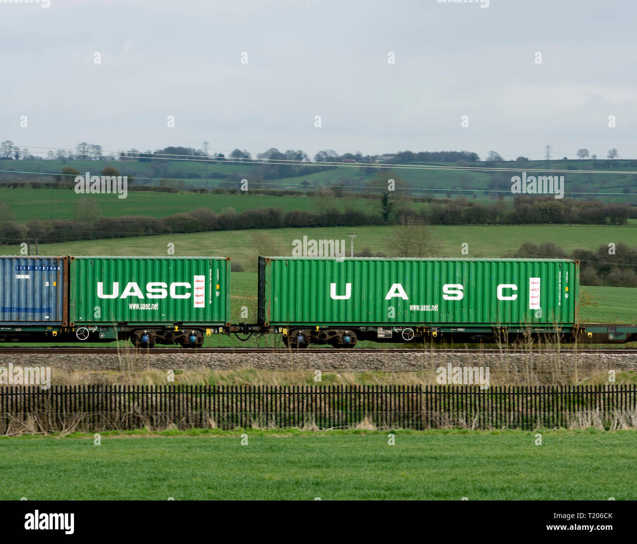 UASC shipping containers on a freightliner train, West Coast Main Line, Northamptonshire, UK Stock Photo