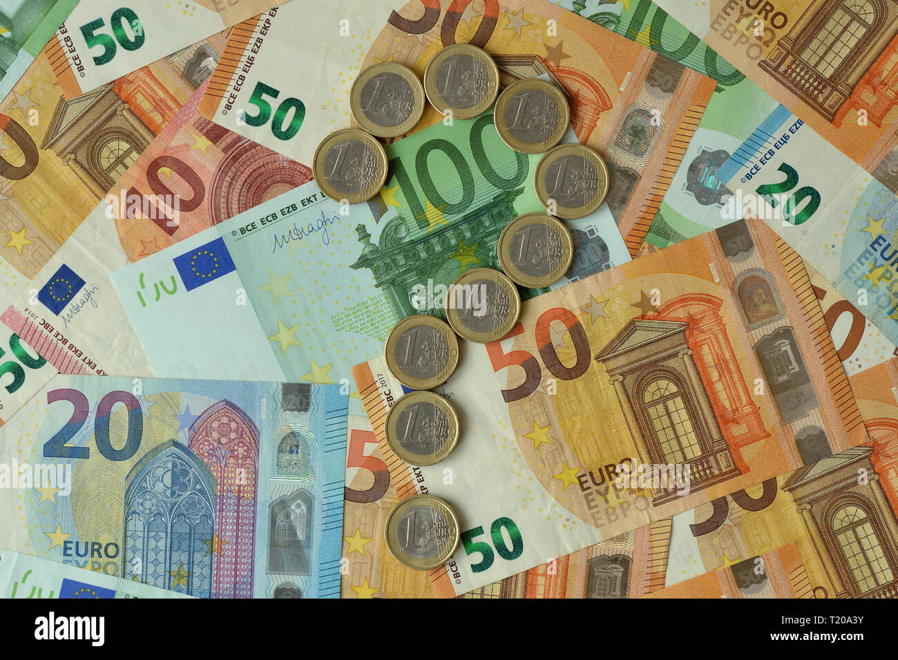 Question mark made of euro coins on euro banknotes background - Concept of financial uncertainty, crisis and uncertain future of euro Stock Photo