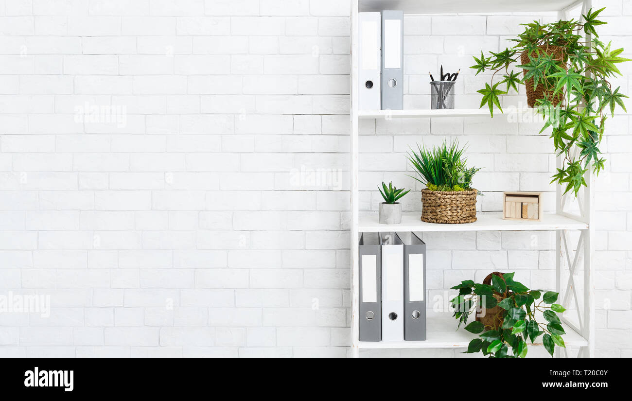 Stand With House Plants And Folders In Office At White Brick Wall Background Copy Space T20C0Y 