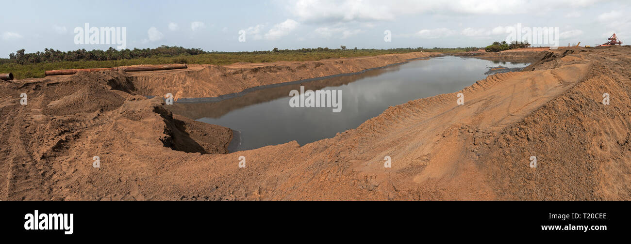 Port operations for managing and transporting iron ore. Future site extension with water area being reclaimed with sand from dredging sea channel Stock Photo
