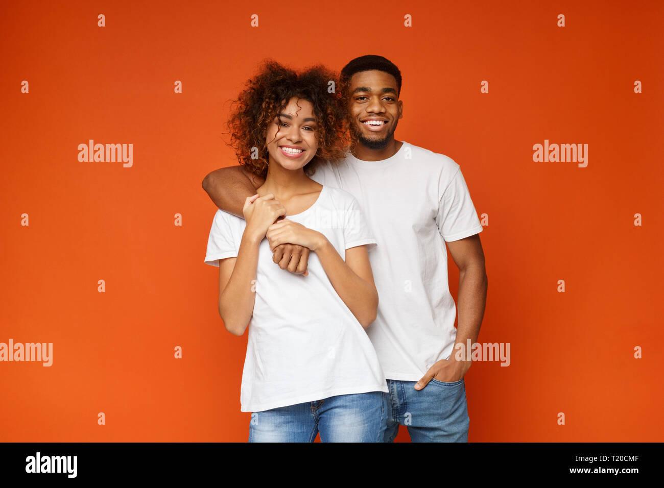 Adorable african-american couple in love smiling at camera, posing on ...