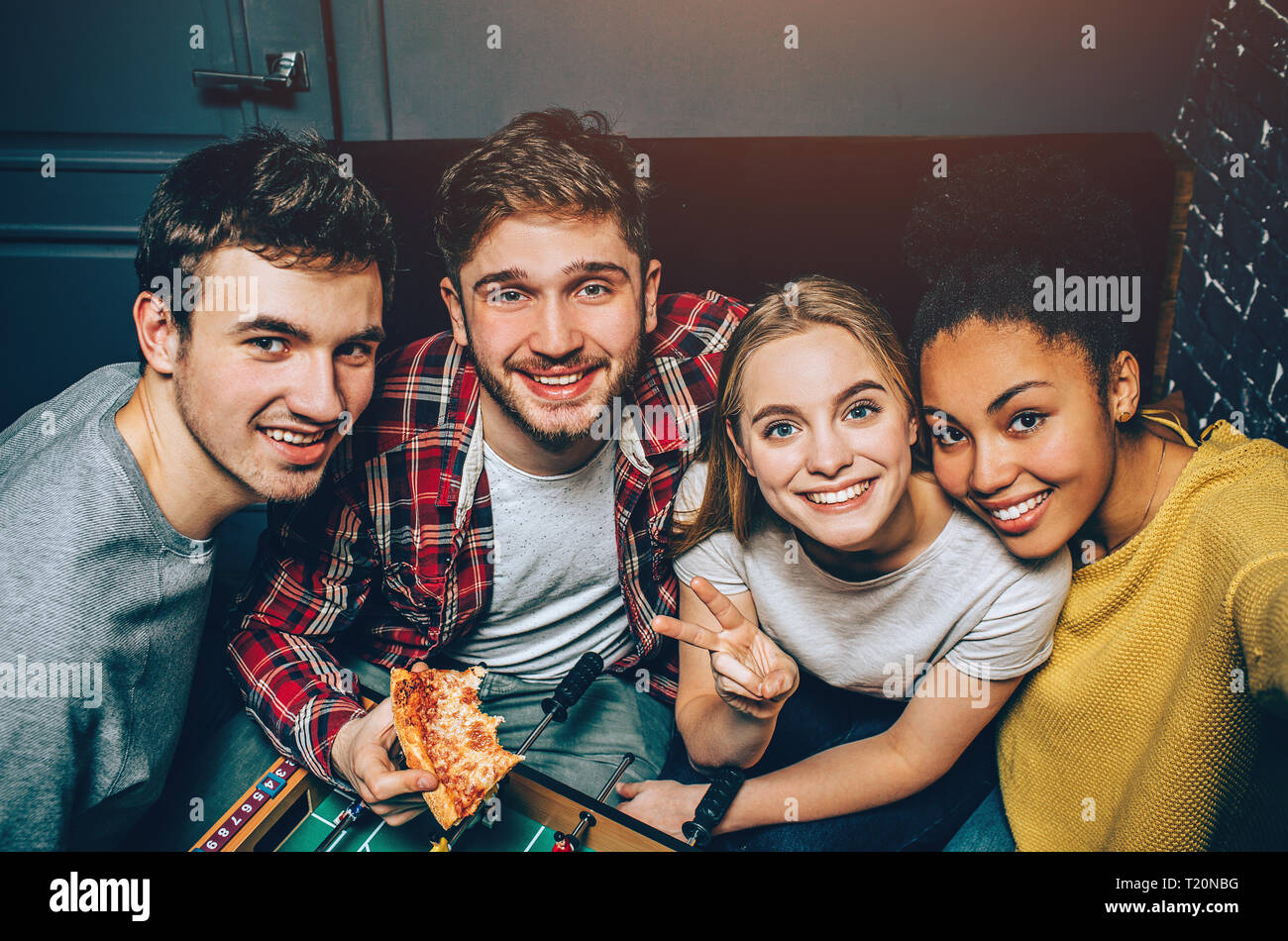 Group Picture Of Four Happy Person That Decided To Stay Together All Day Long In Playing Room That Had A Good Time Guys And Girls Look Happy And Coo Stock Photo