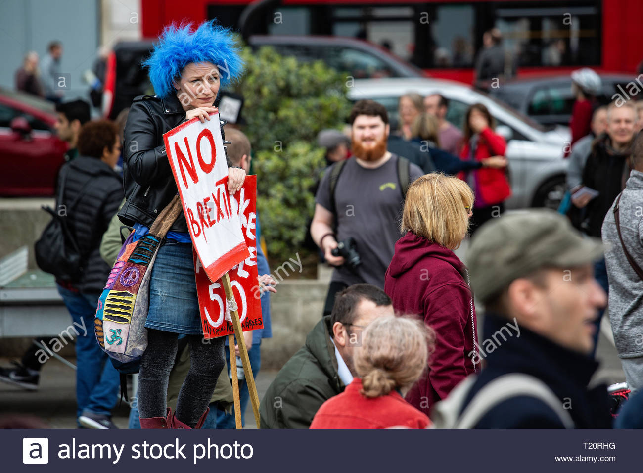 A woman in a blue wig and holding a No Brexit sign looks ruefully at a crown at Marble Arch Stock Photo