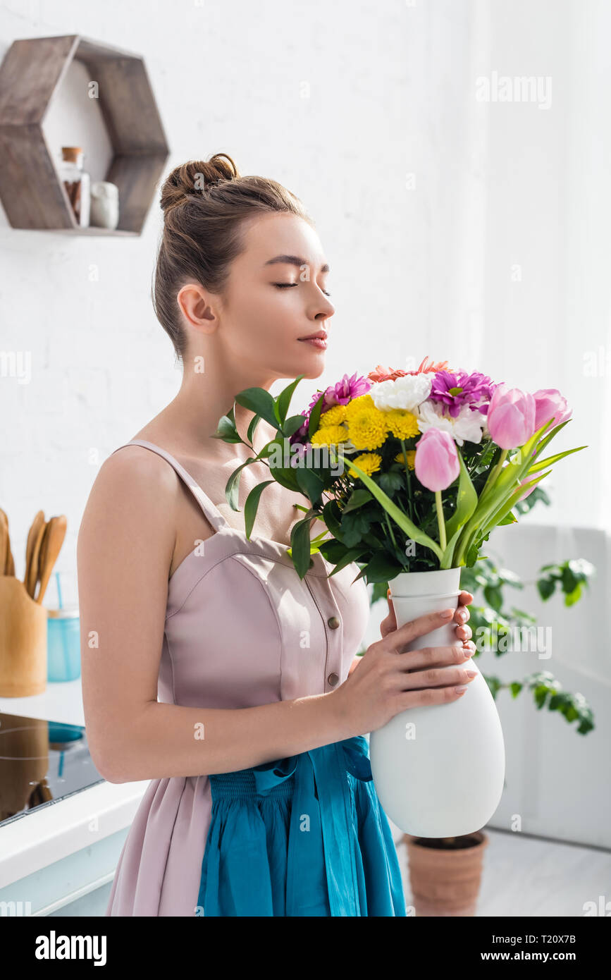 pretty smiling girl with closed eyes smelling bouquet of wildflowers in ...