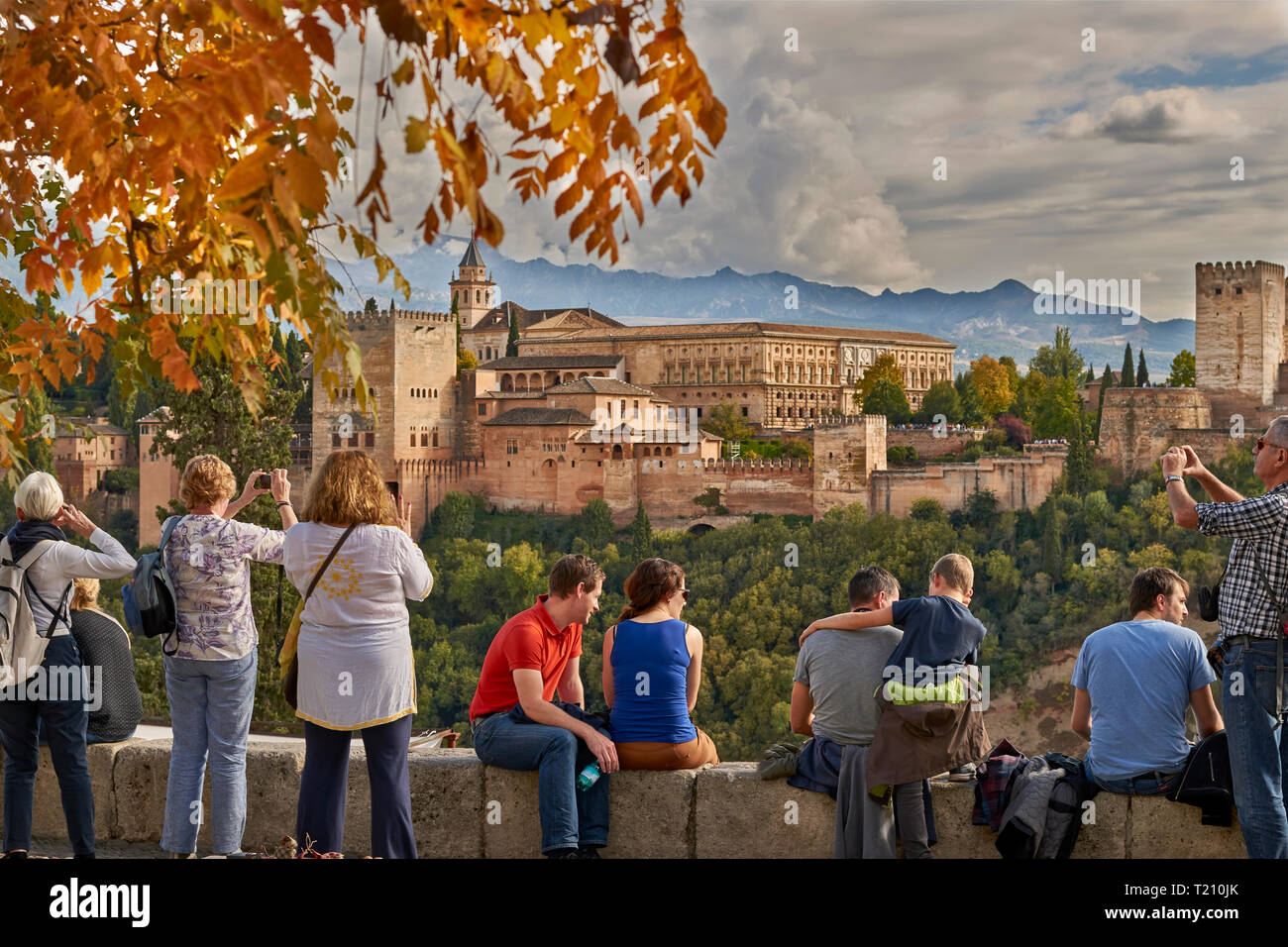 SPAIN ANDALUSIA GRANADA THE ALHAMBRA PEOPLE ENJOYING THE VIEW OF THE SPECTACULAR FORTIFIED CASTLE AND SIERRA NEVADA MOUNTAINS Stock Photo