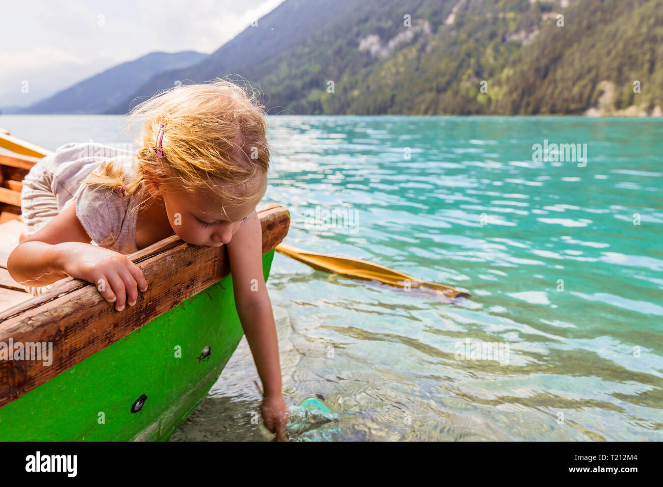 Austria, Carinthia, Weissensee, girl in rowing boat putting her hand in the water Stock Photo