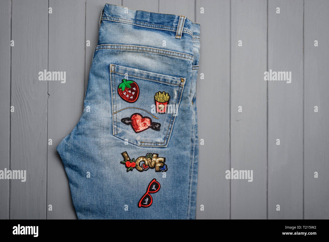 Patched jeans on wooden background Stock Photo