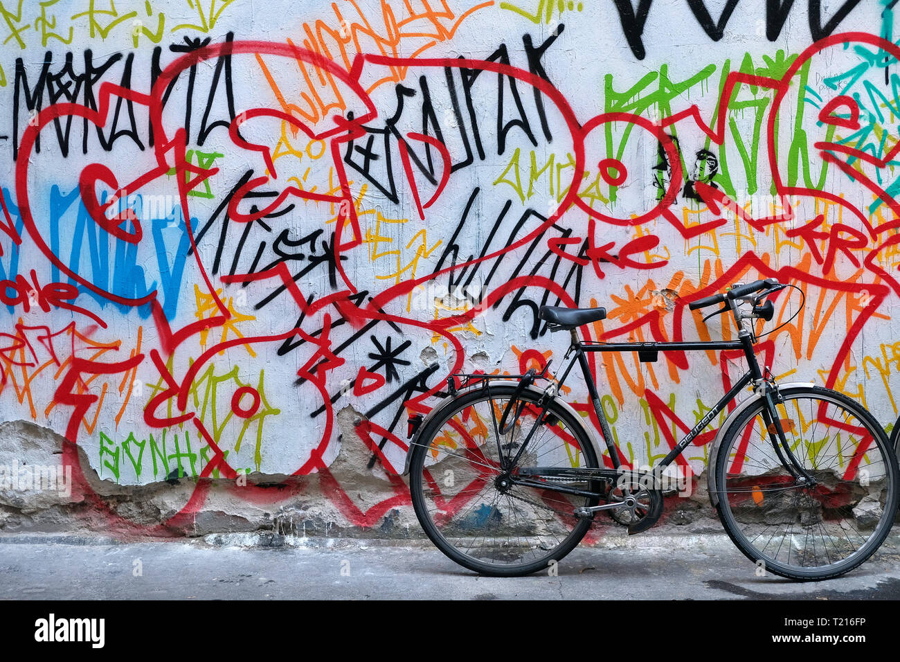 Bicycle in front of colorfully painted wall. Stock Photo