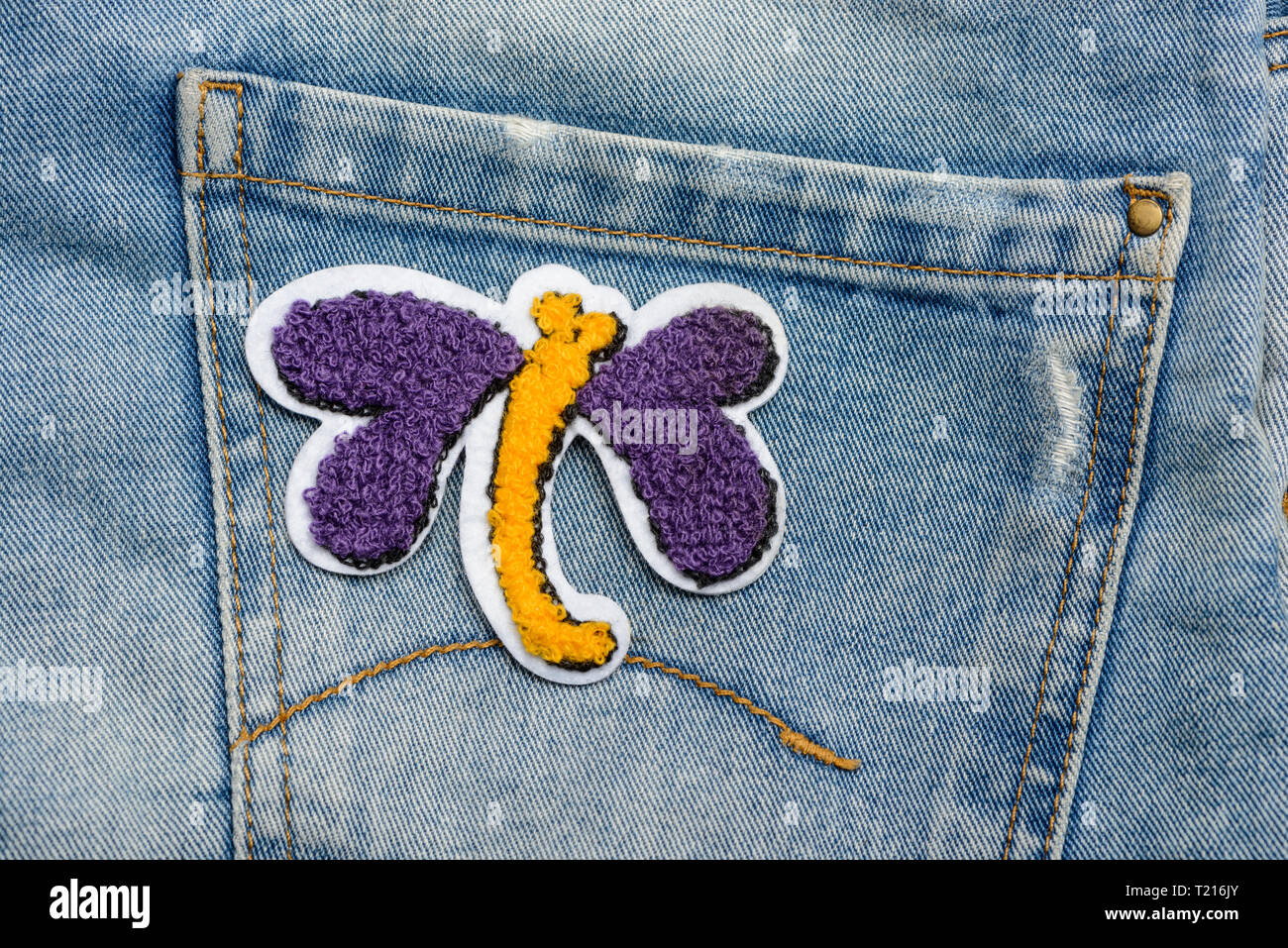 Butterfly fabric patch on jeans Stock Photo