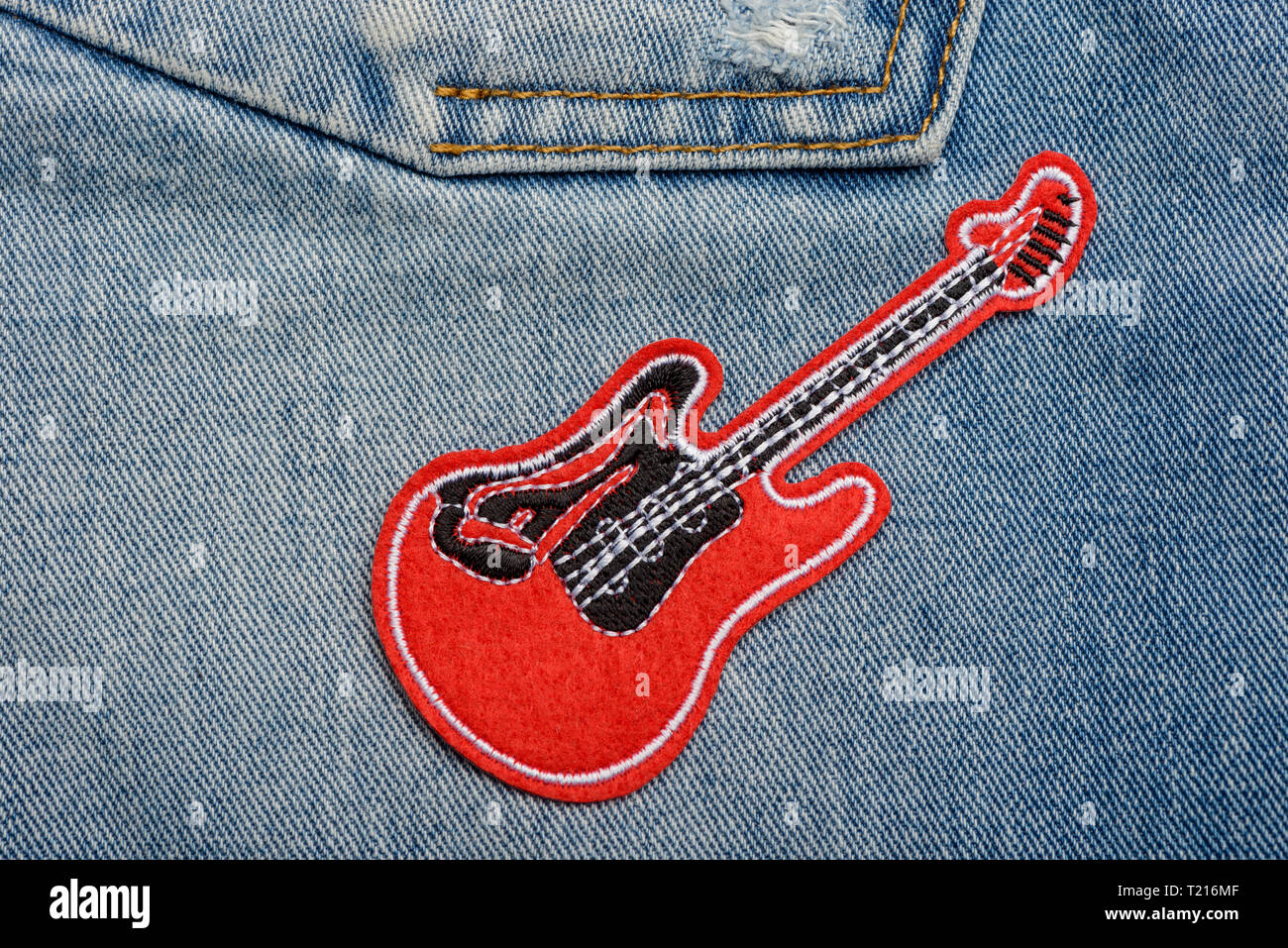 Red guitar patch on jeans Stock Photo