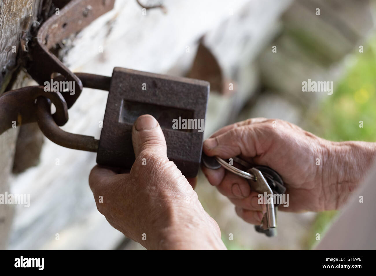 Old Man Hands Holding Metal Vintage Lock And Key To Open