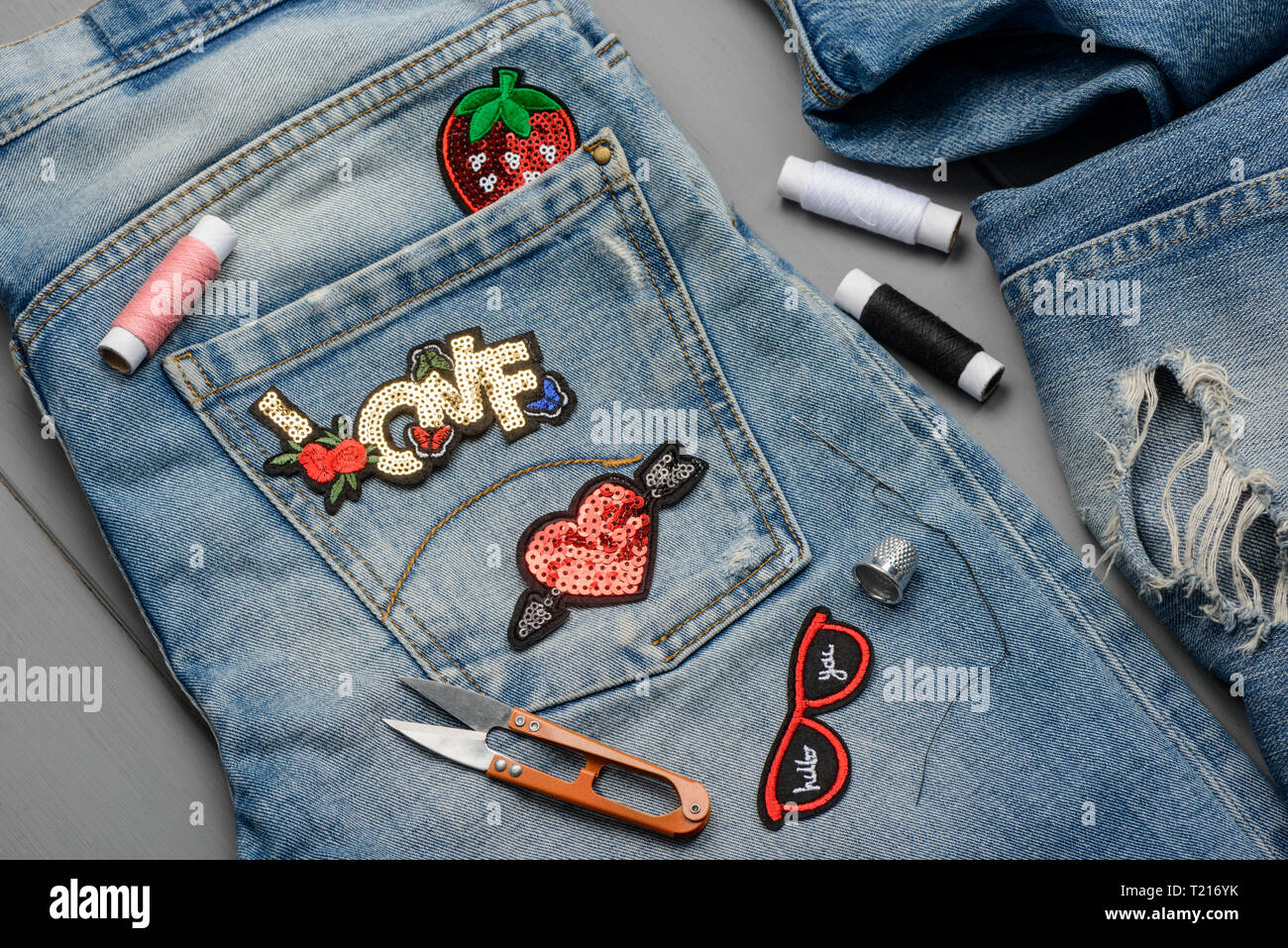 Applying patches to jeans Stock Photo