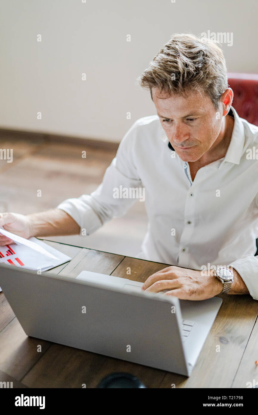 Focused businessman using laptop at desk Stock Photo