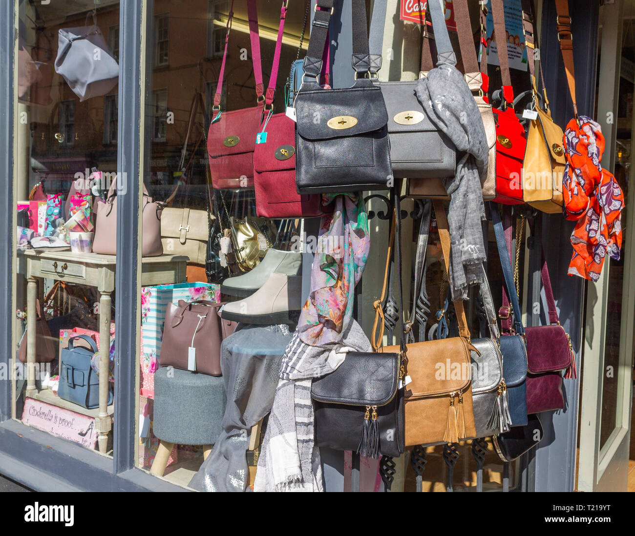 leather handbags hanging on display in shop window. Stock Photo