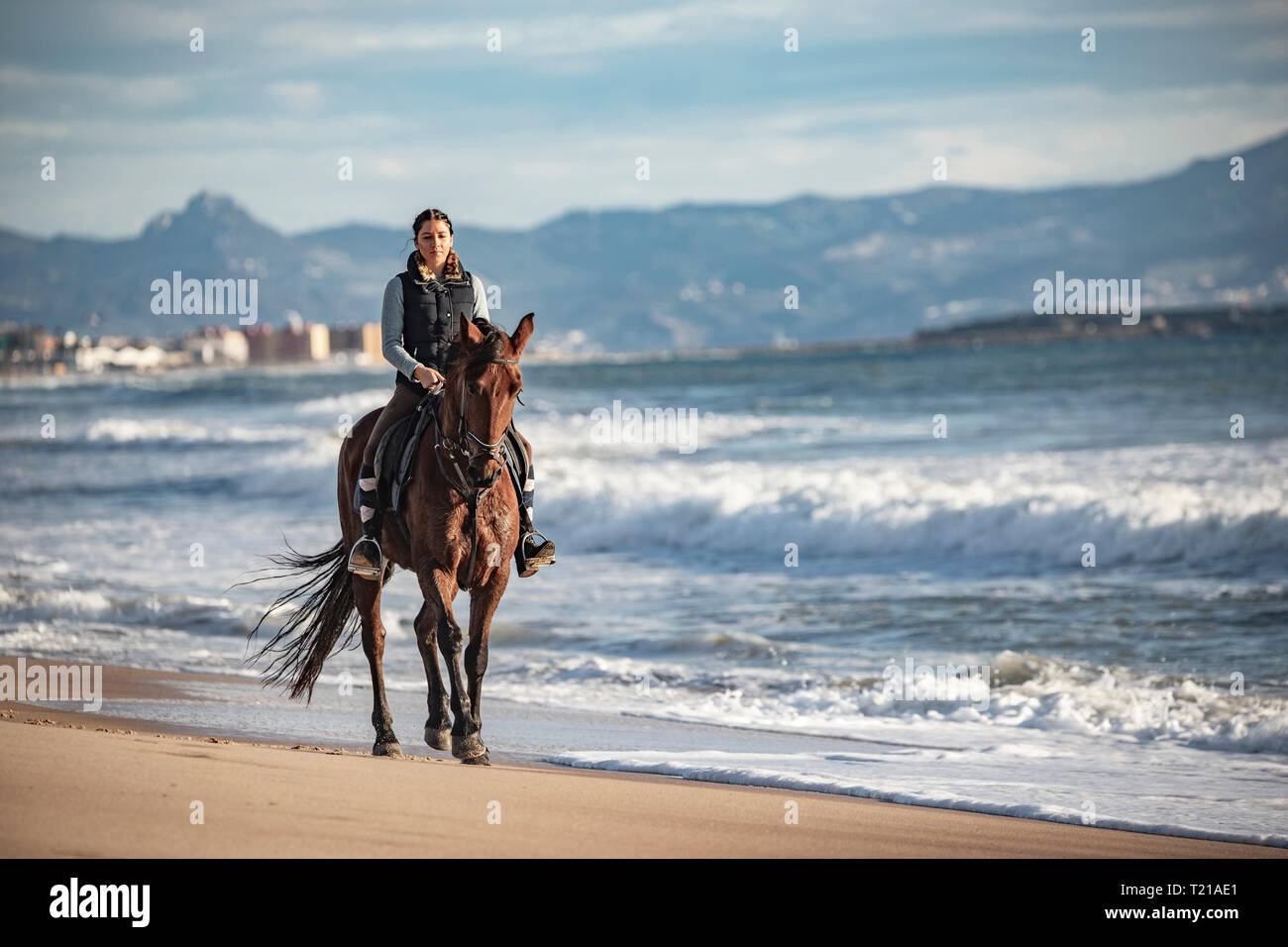 Spain, Tarifa, woman riding horse on the beach Stock Photo