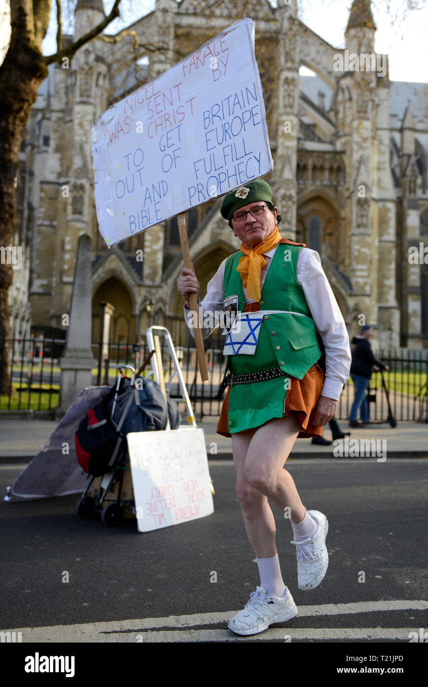A protester seen holding a banner that says “ Nigel Farage was sent by Christ to get Britain out of Europe and fullfil bible prophecy during the Leave means leave rally in London.  A Leave means leave pro Brexit march begun on March 16 in Sunderland, UK and ended with a rally in Parliament Square on March 29 in London, same day that UK has been scheduled to leave the European Union. Pro Brexit protesters gathered at Parliament Square to demand from the government to deliver what was promised and leave the European Union without a deal. Nigel Farage and Tommy Robinson were seen giving speeches  Stock Photo