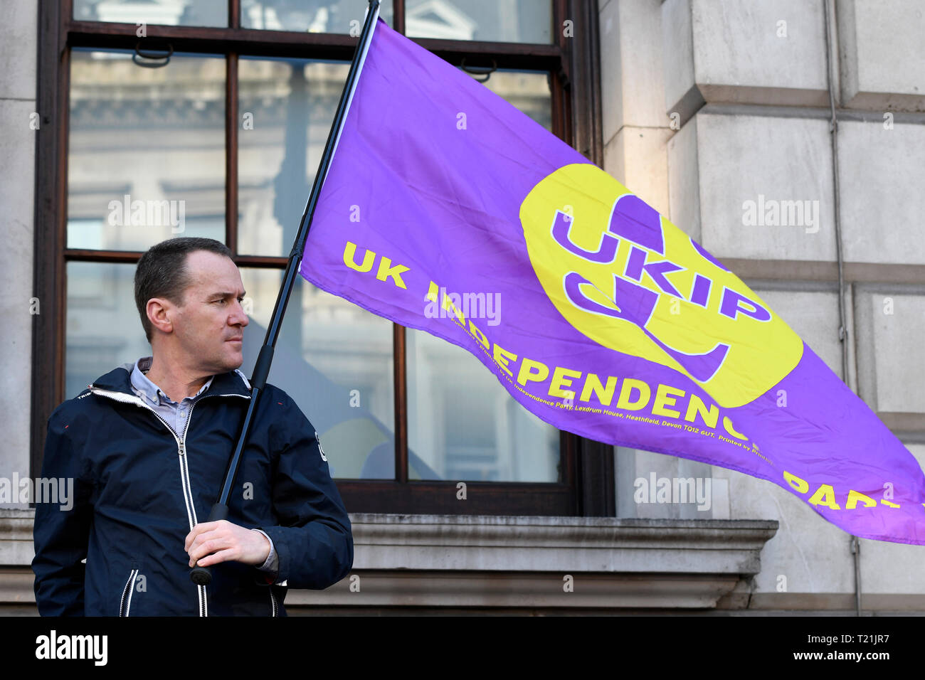 A pro Brexit protester and UKIP supporter seen carrying a UKIP flag during the Leave means leave rally in London.  A Leave means leave pro Brexit march begun on March 16 in Sunderland, UK and ended with a rally in Parliament Square on March 29 in London, same day that UK has been scheduled to leave the European Union. Pro Brexit protesters gathered at Parliament Square to demand from the government to deliver what was promised and leave the European Union without a deal. Nigel Farage and Tommy Robinson were seen giving speeches to their supporters in different stages during the pro Brexit prot Stock Photo