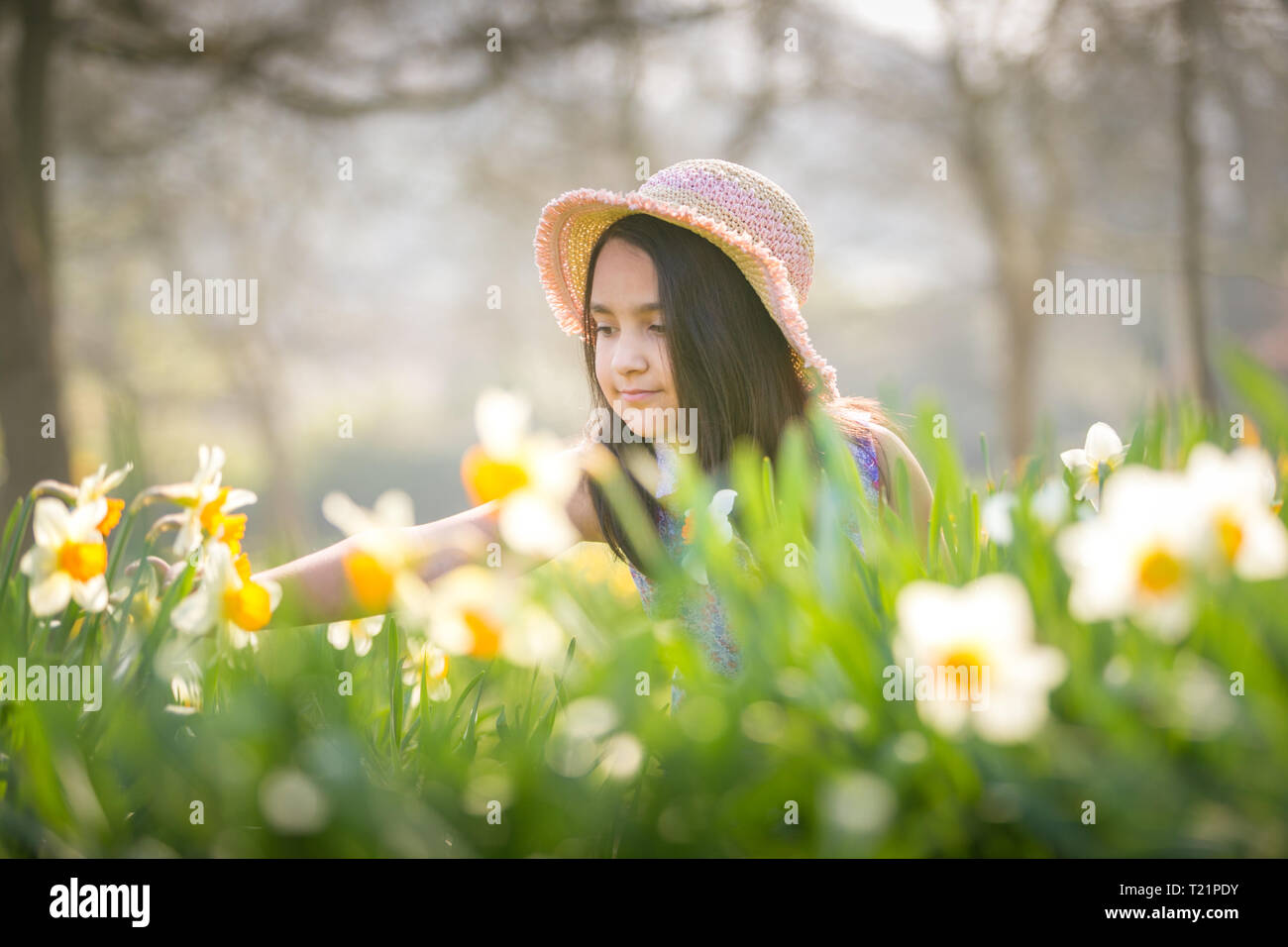 . Eight-year-old Ellie May enjoys the spring flowers as the UK has a weekend of sun and warmth before temperatures dip next week. Credit: Peter Lopeman/Alamy Live News Stock Photo