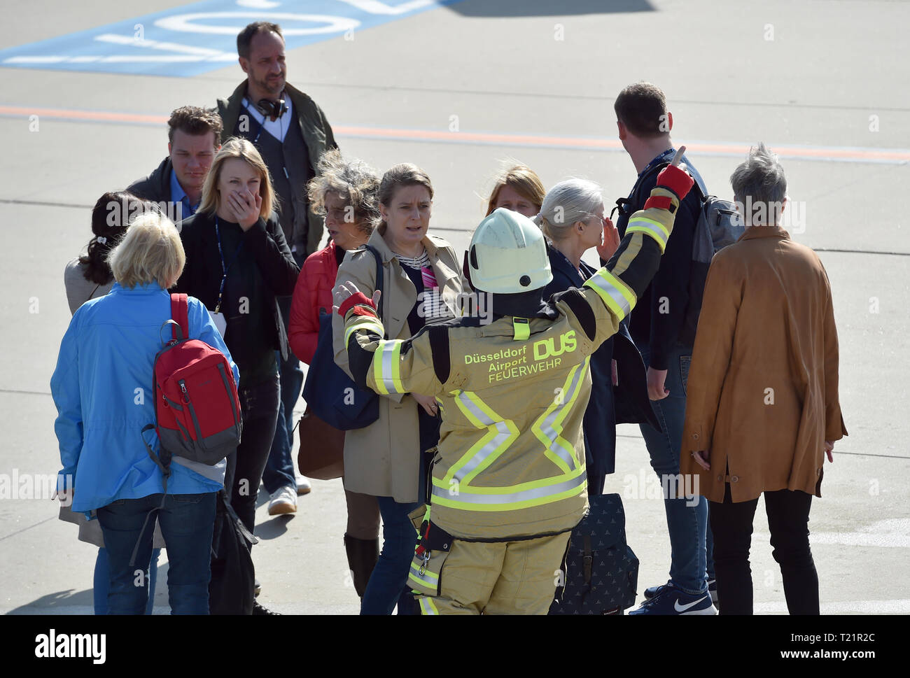 Dusseldorf, Germany. 30th Mar, 2019. Employees of the airport fire brigade help 'victims' played by extras during the air accident exercise 'Tango 2019' on the tarmac of the airport. Such exercises must be carried out at the airport every two years. Photo: Caroline Seidel/dpa Credit: dpa picture alliance/Alamy Live News Stock Photo