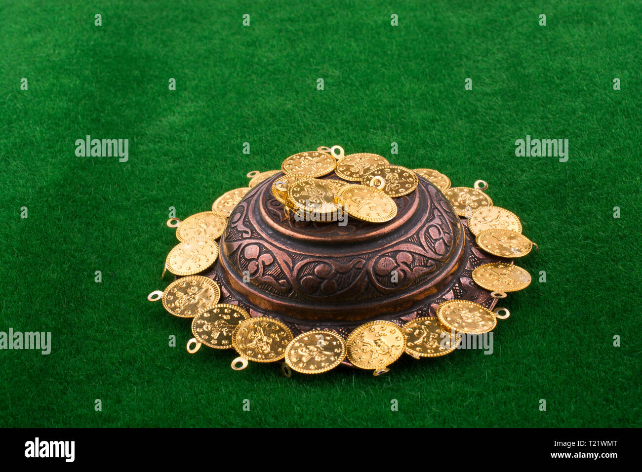 Fake gold coins around an old decorative metal plate Stock Photo Alamy
