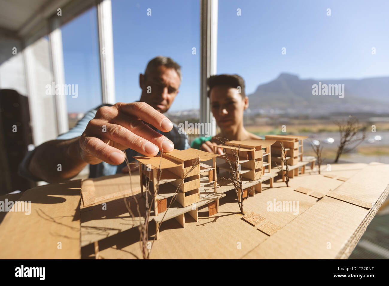 Architects discussing over architectural model Stock Photo