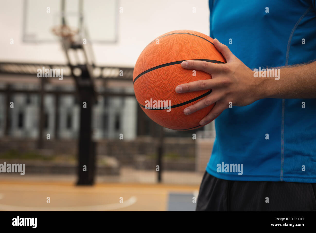 Basketball player standing with basketball in playground Stock Photo