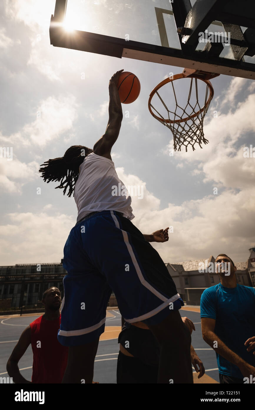 African basketball player jumping to score a hoop while others looking at him Stock Photo Alamy