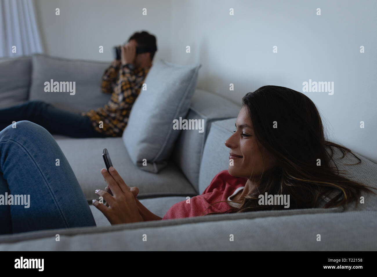 Woman using mobile phone while man using virtual reality headset Stock Photo
