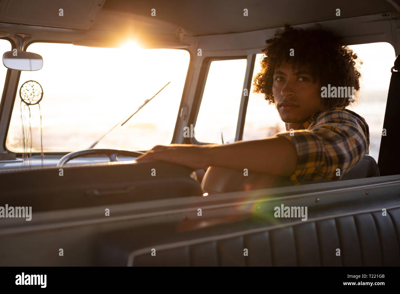 Mixed-race man turning back to looking the camera in a camper van Stock Photo