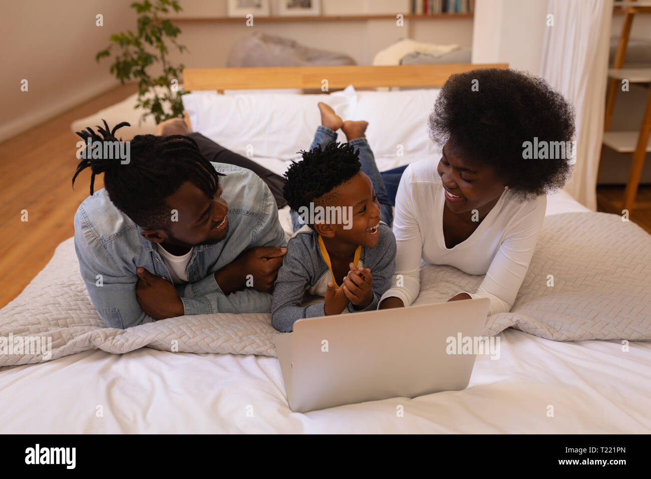 Family together enjoying while using laptop at home Stock Photo