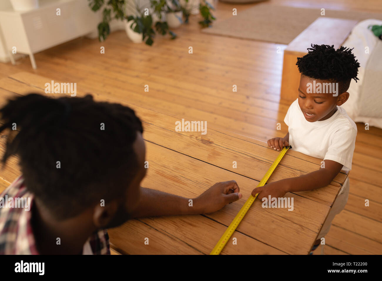 Father and son measuring table with measurement tape Stock Photo