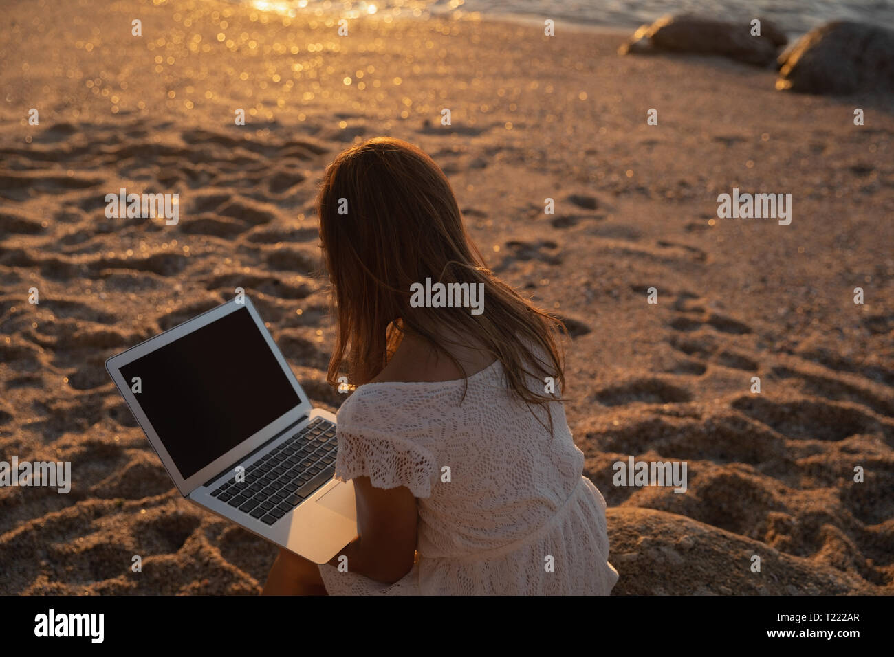 Beautiful woman using laptop at beach Stock Photo - Alamy