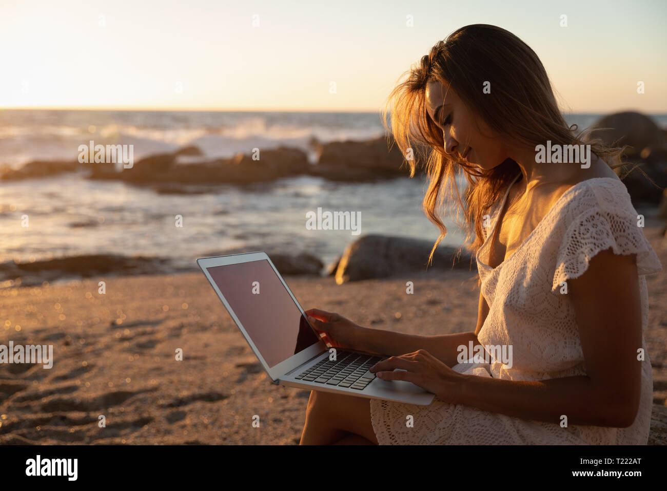 Beautiful woman using laptop at beach Stock Photo - Alamy