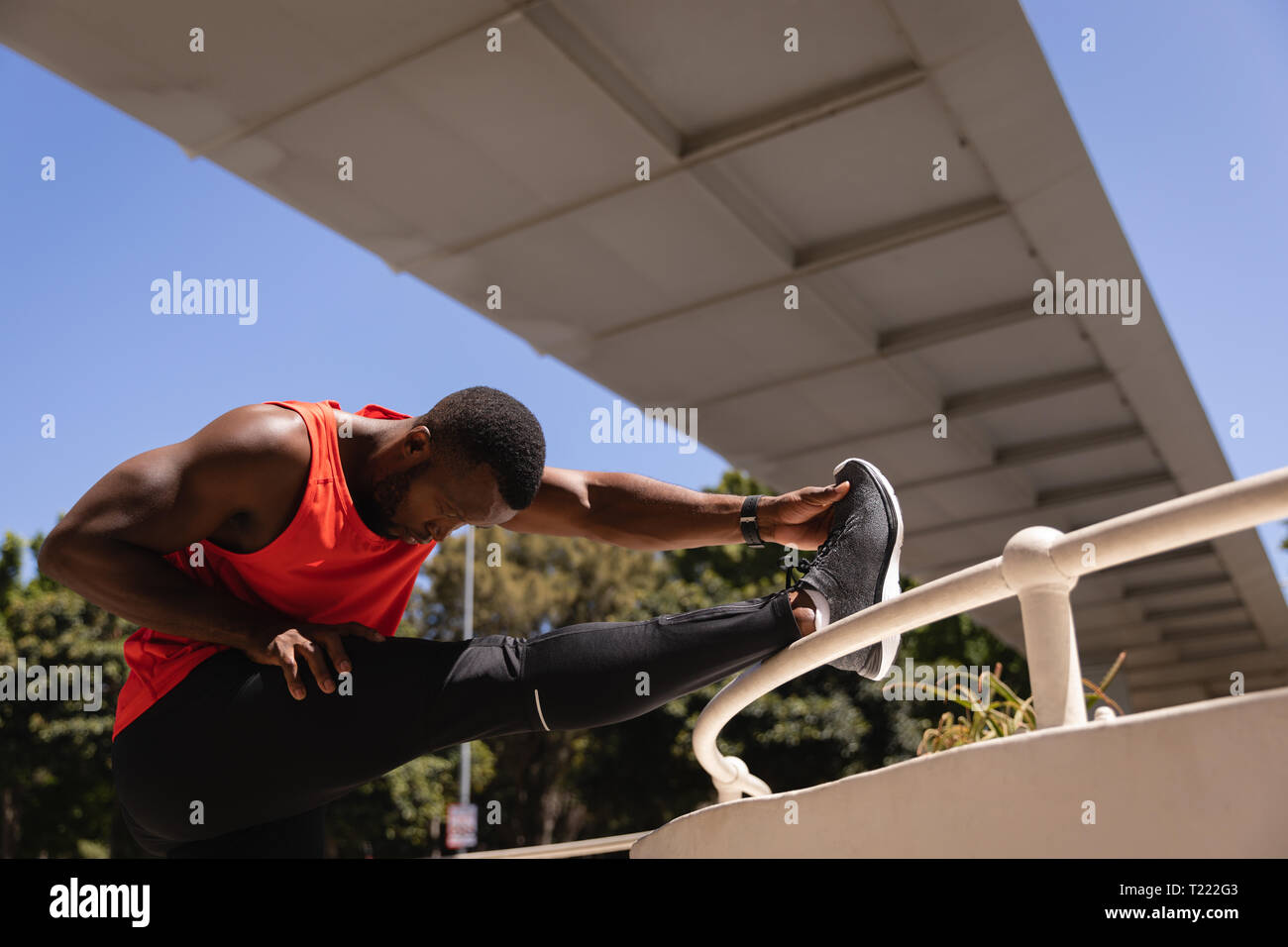Young man doing exercise under the bridge on railing Stock Photo