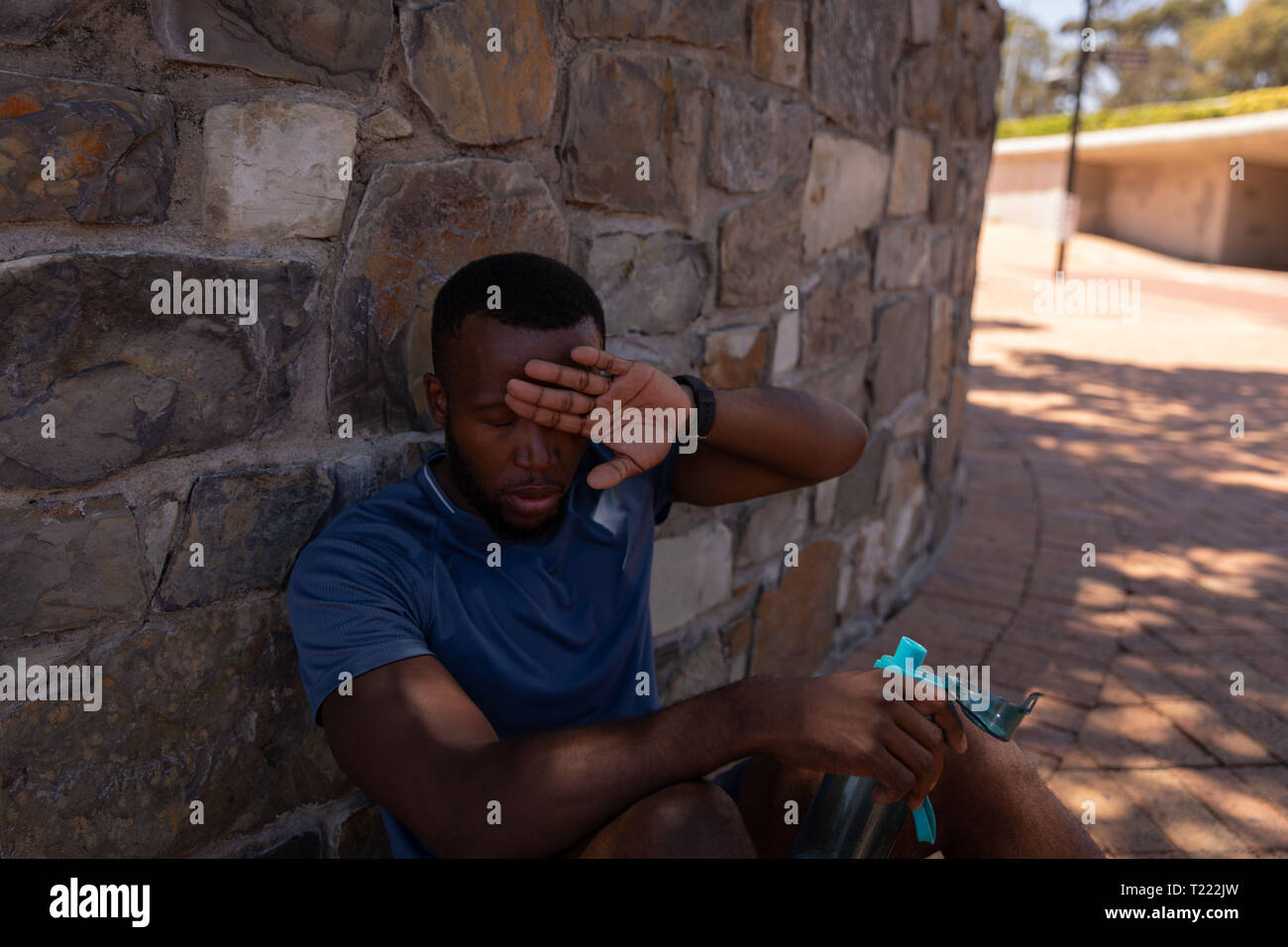 Man relaxing beside wall on a sunny day Stock Photo