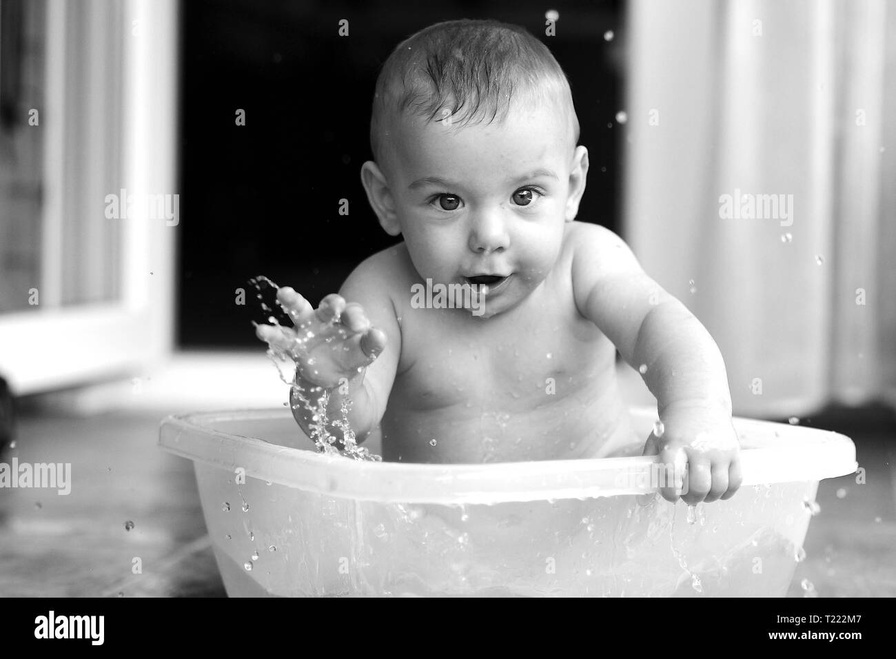 Baby playing with water in a dish pan Stock Photo - Alamy