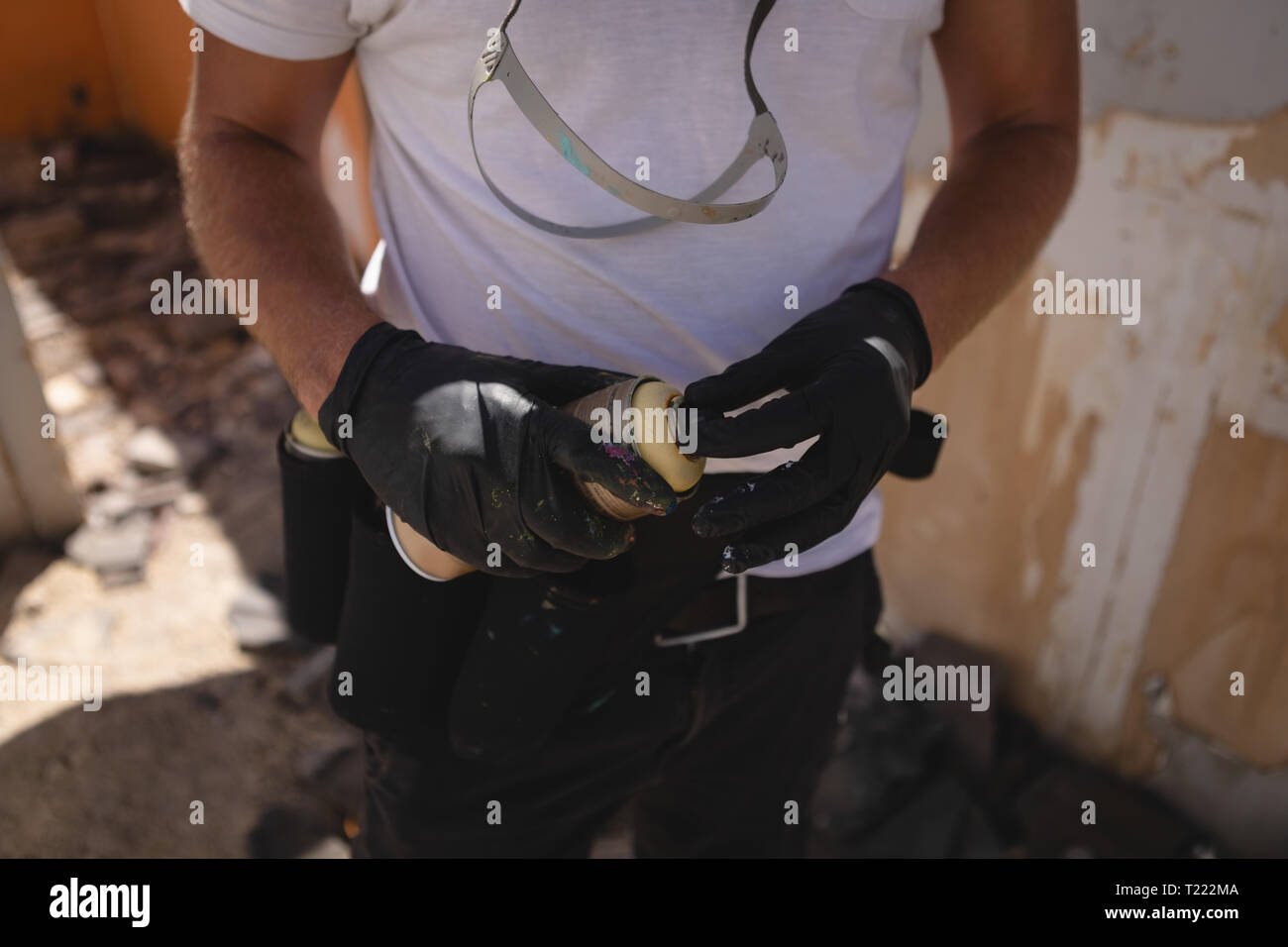 Graffiti artist standing with spray painting at alley Stock Photo - Alamy