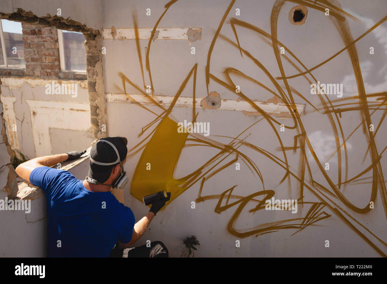 Graffiti artist spray painting weathered wall Stock Photo - Alamy