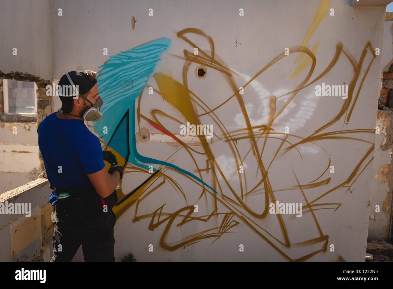 Graffiti artist looking at weathered wall room Stock Photo - Alamy