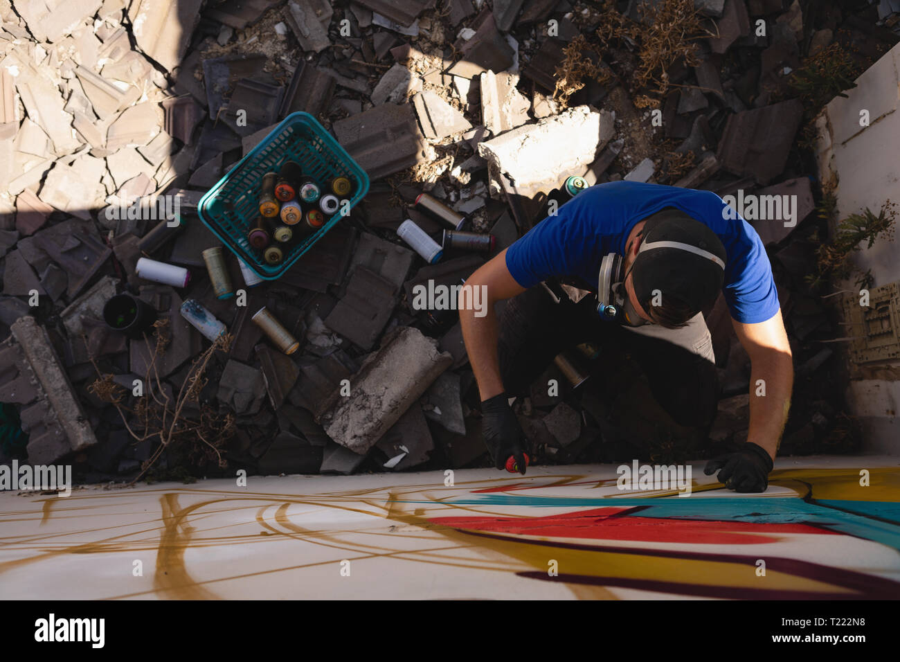 Graffiti artist spray painting weathered wall room Stock Photo - Alamy