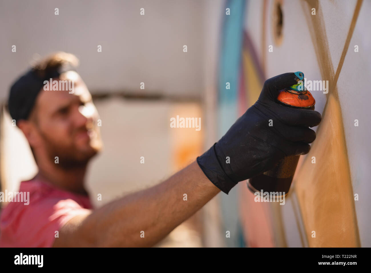 Graffiti artist spray painting on weathered wall room Stock Photo - Alamy
