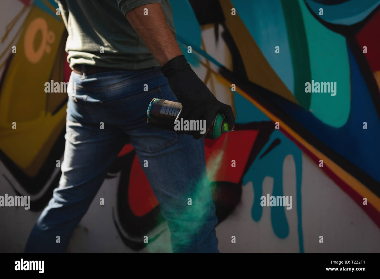 Graffiti artist spray painting on weathered wall Stock Photo Alamy