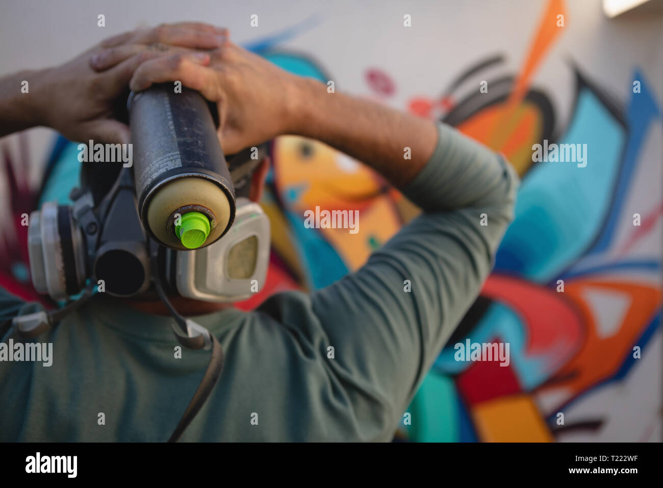 Graffiti artist holding painting spray in font of the wall Stock Photo ...