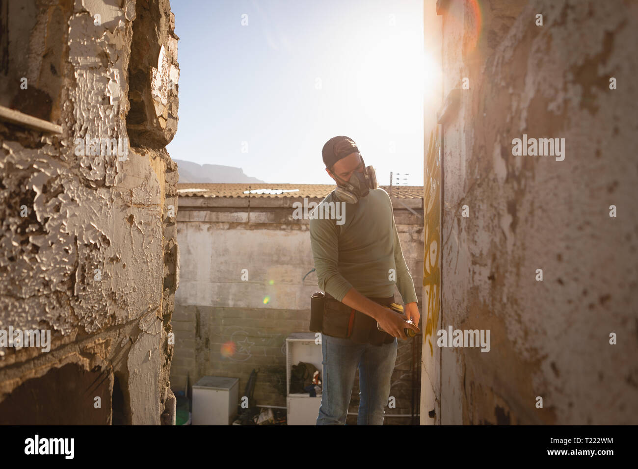 Graffiti artist spray painting on weathered wall Stock Photo - Alamy