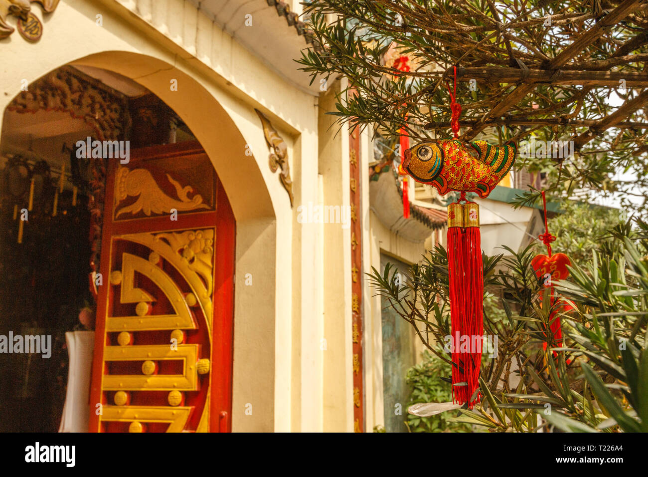 Red and gold carps hanging near Buddhist temple in Old Quarter - decoration for celebrating Tet, Vietnamese new year in Hanoi, Vietnam. Stock Photo