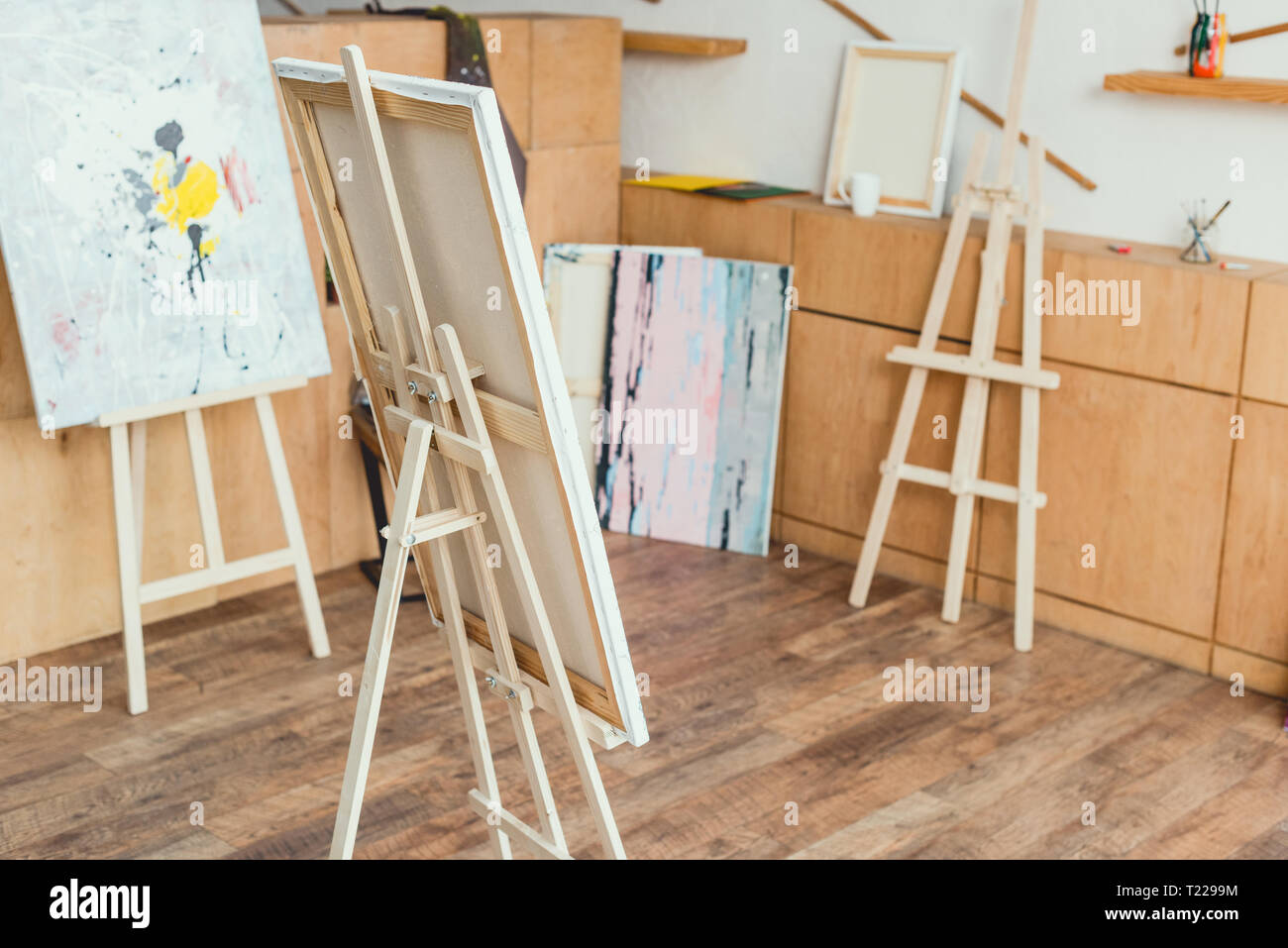 Painting Studio With Wooden Floor Cabinets Easels And Paintings